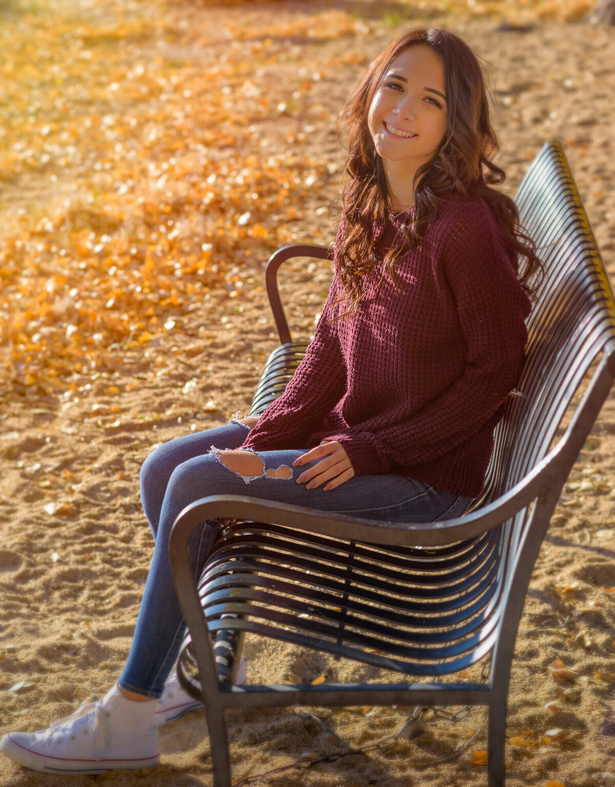 Girl smiles on park bench in Prescott senior photos
