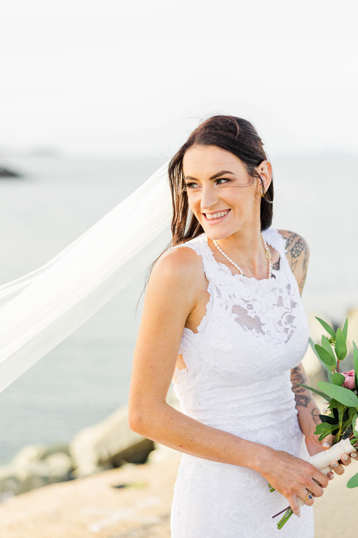 bride laughs over her shoulder during sunsets portraits on her mackay wedding day