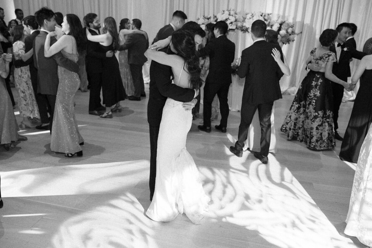 A bride and groom embracing on the dance floor at the Art Institute of Chicago, captured in a timeless black and white moment.