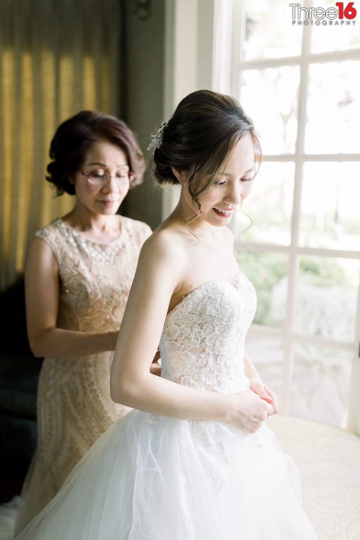 Mother of the Bride buttons her daughter's wedding dress