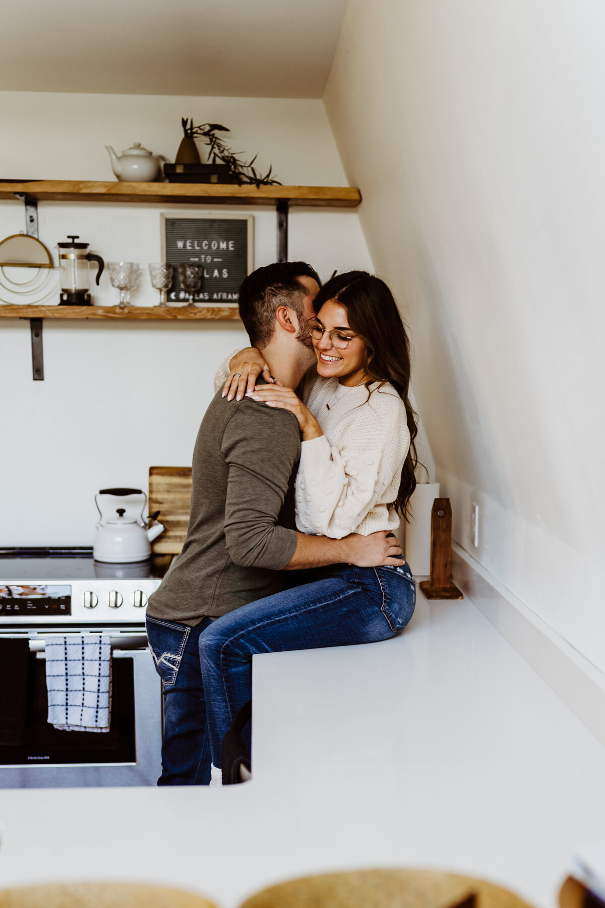 couple hugging and laughing on kitchen counter