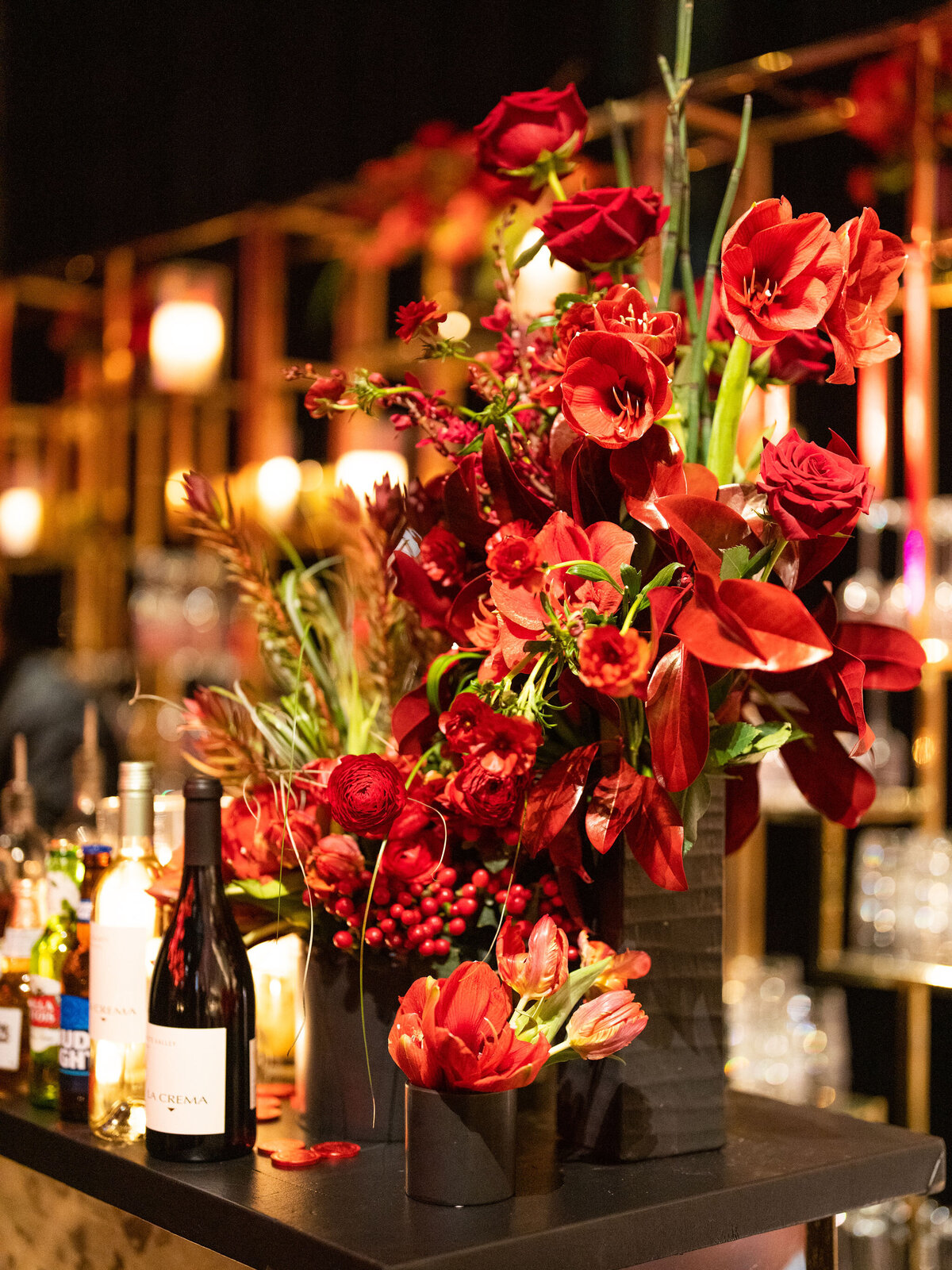 A vibrant arrangement of red roses and foliage decorates the wedding bar, adding a bold and romantic touch.