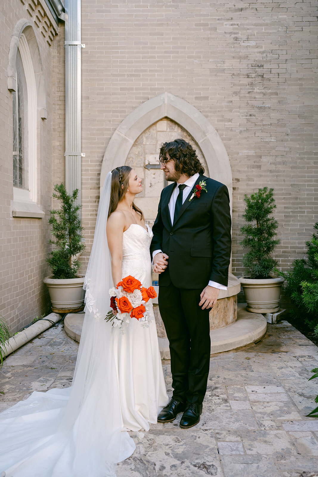 Newlywed couple portrait with florals on steps of San Antonio luxury wedding venue entrance