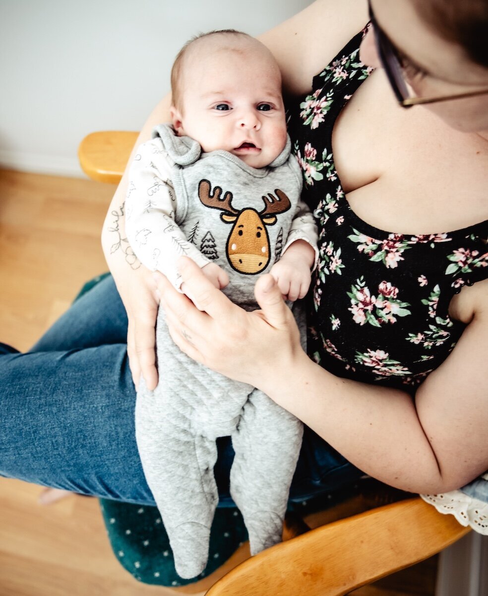 A mom holds her newborn baby in her nursery