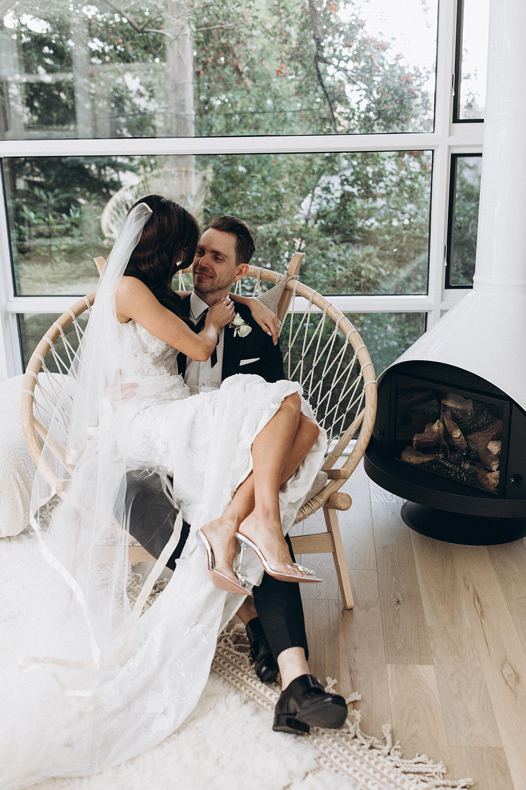 Bride and groom sitting together in a boho round rattan chair, captured by Bryttanni,  luxury and artistic wedding photographer in Edmonton, Alberta. Featured on the Bronte Bride Vendor Guide.