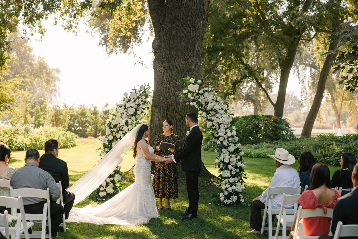 bride and groom standing hand in hand at alter during ceremony
