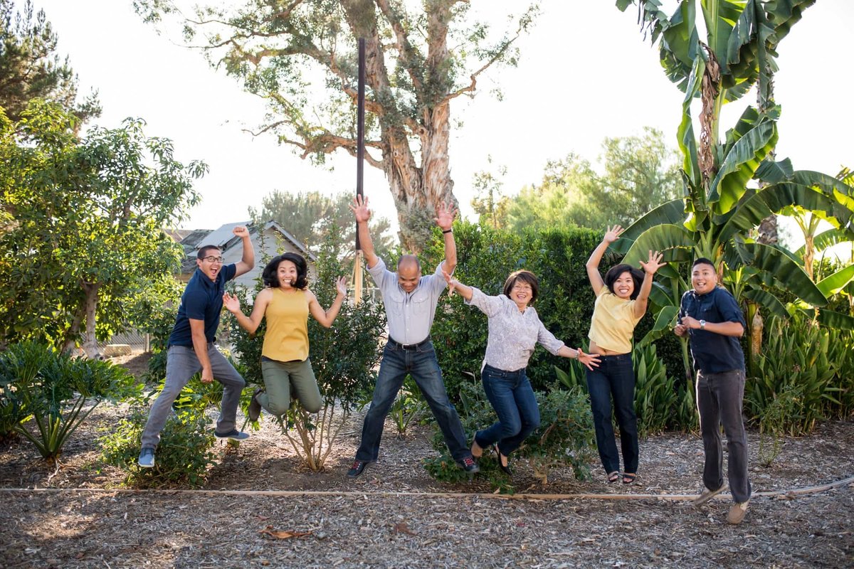 Family of six jump for joy during a family outing and photo session