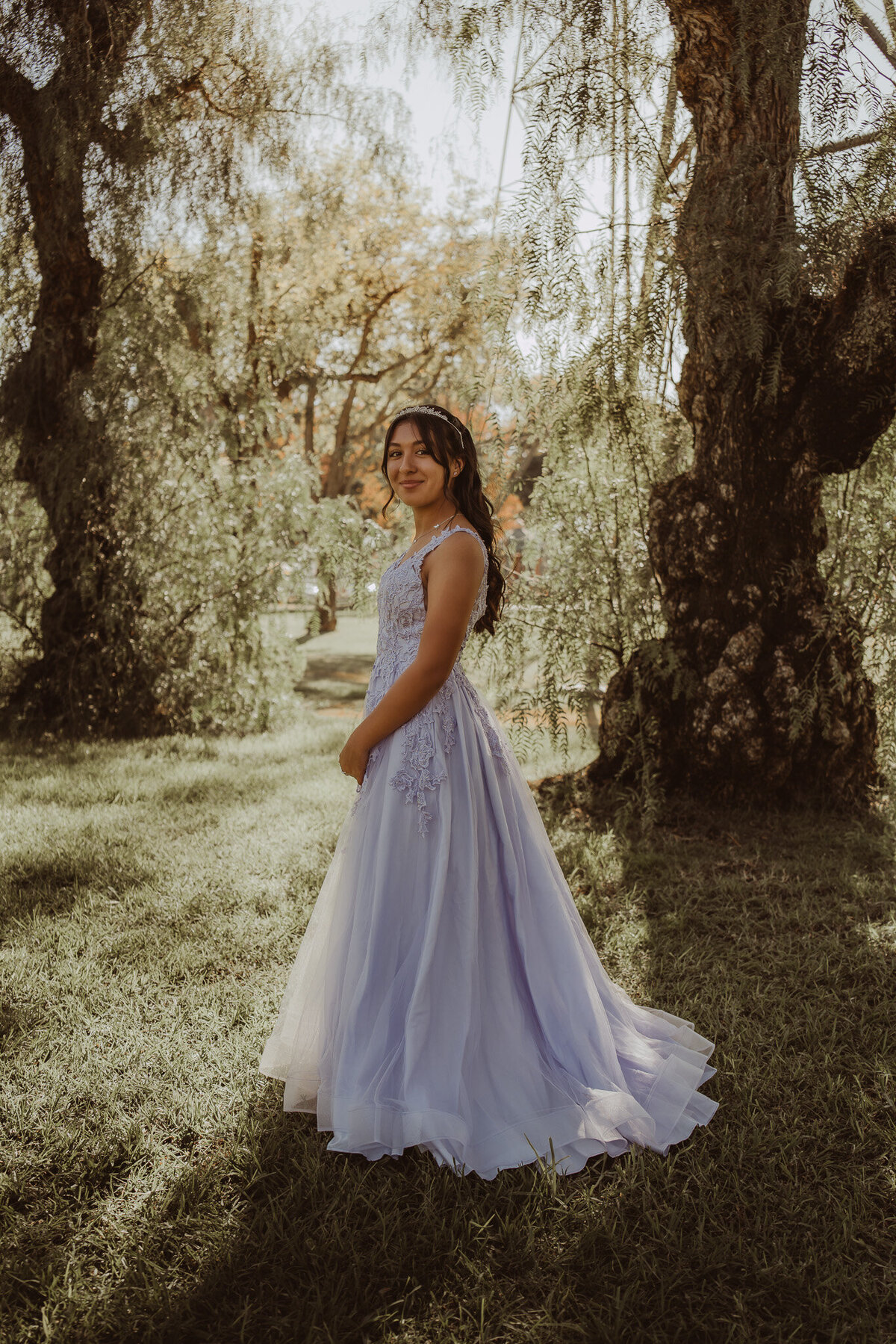 a young girl in a long purple gown at a park 