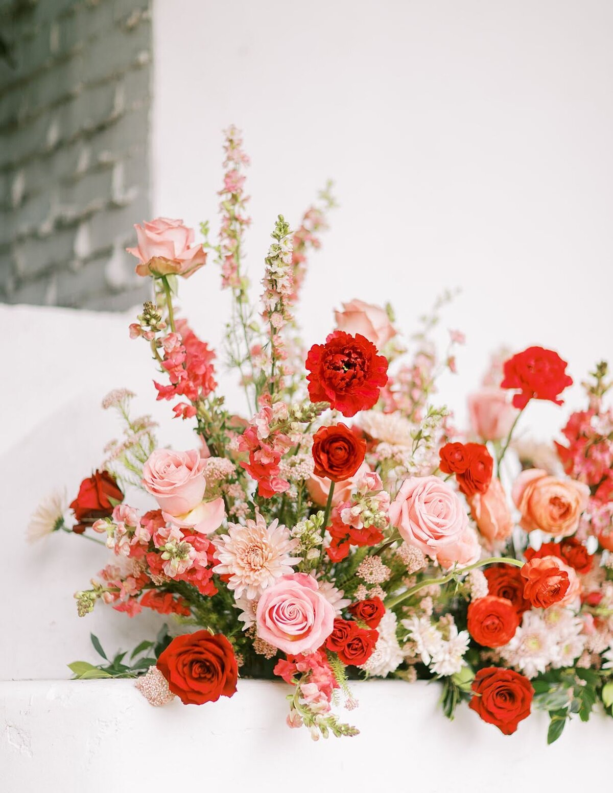 Fireplace floral installation with red and pink flowers at The Casino San Clemente