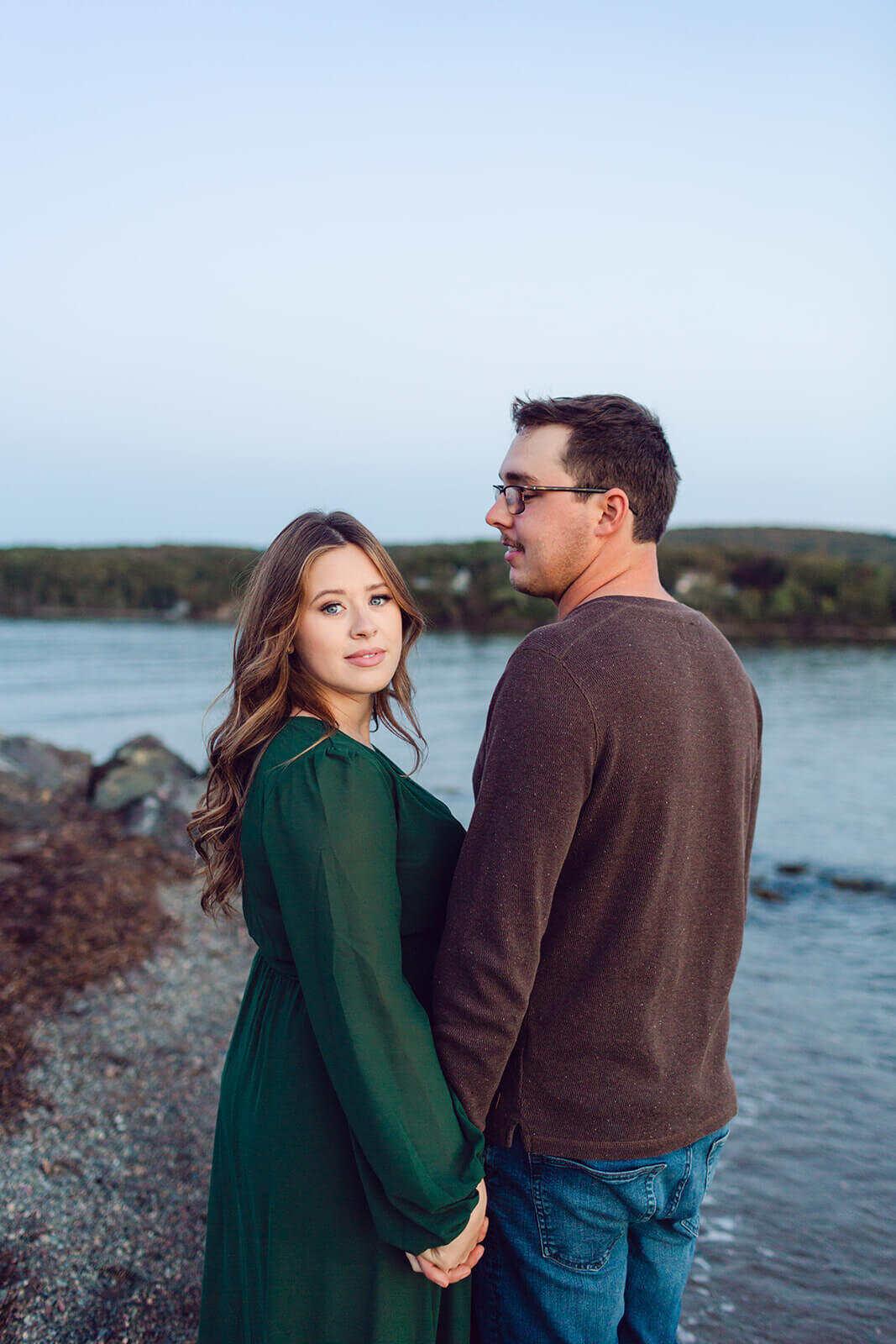 pregnant-woman-in-green-dress-holds-husbands-hands