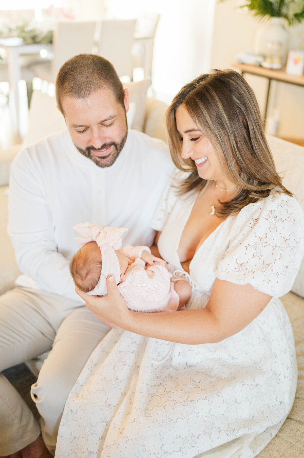 Newborn with mom and dad looking down at her taken in Douglas, MA by the best newborn photographer in central Massachsuetts