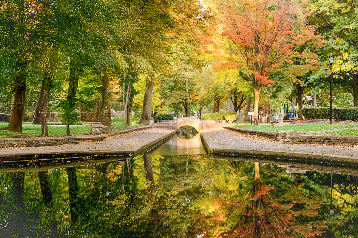Stone bridge surrounded by golden trees during fall mini session at Lititz Springs Park Lititz, PA