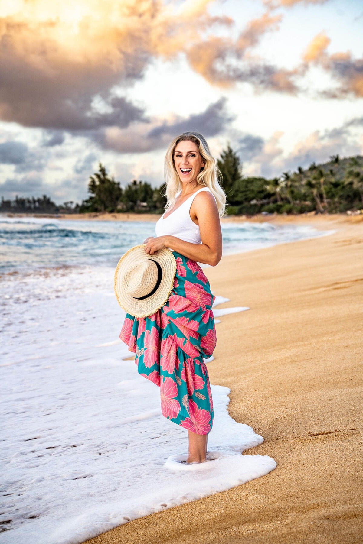 Woman holding skirt and hat by hawaii lifestyle photographer