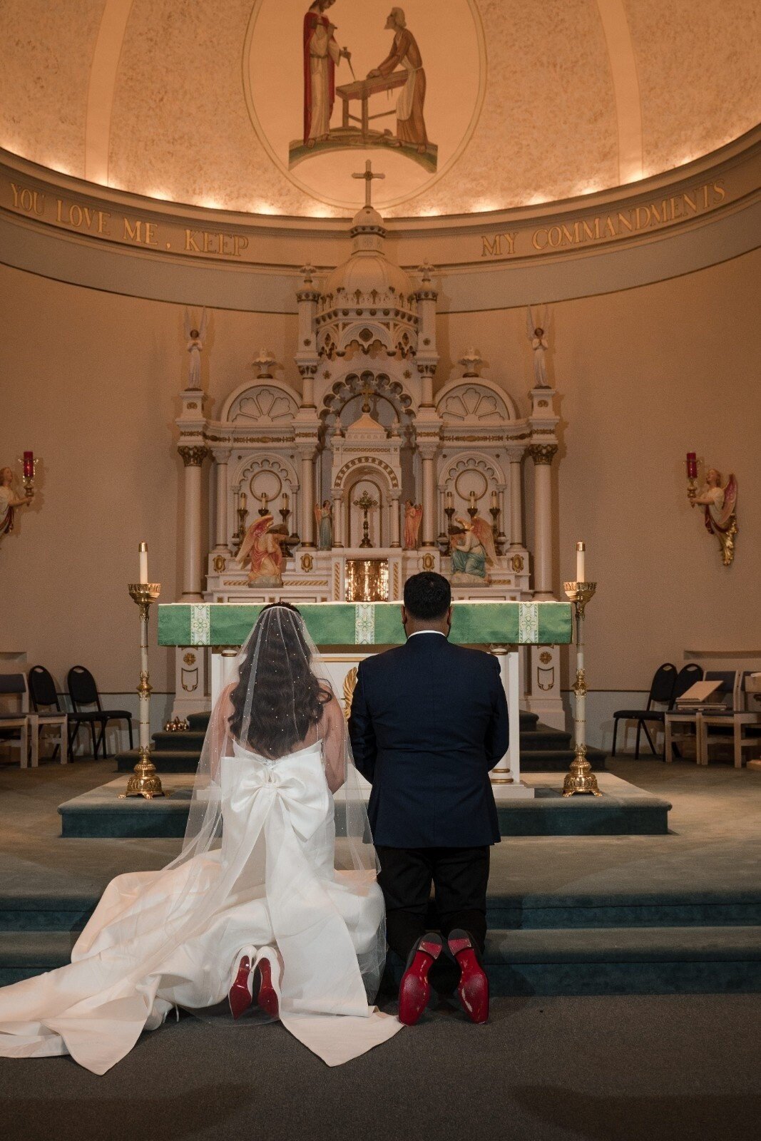 Bride and groom kneel together in prayer at the altar during their wedding at Union Club Hotel