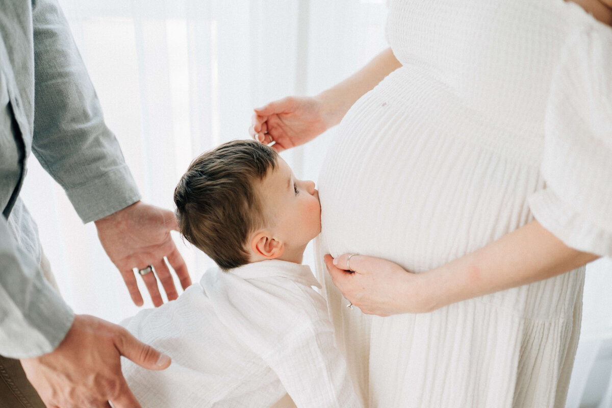 son kissing his pregnant mothers belly