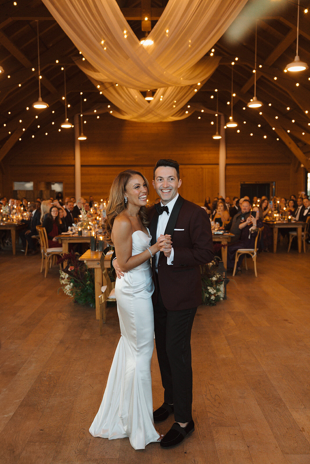 A bride and groom share their first dance inside the reception space at The Lake House on Canandaigua