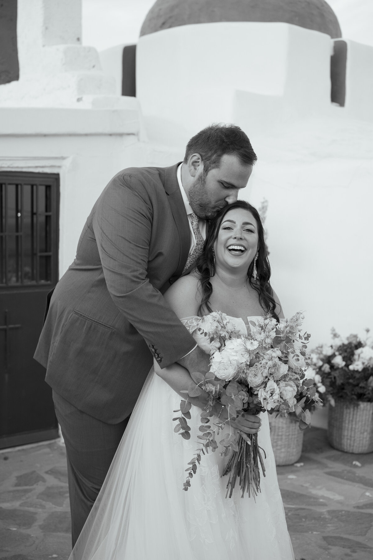 groom kissing bride at a destination island wedding on Paros, Greece