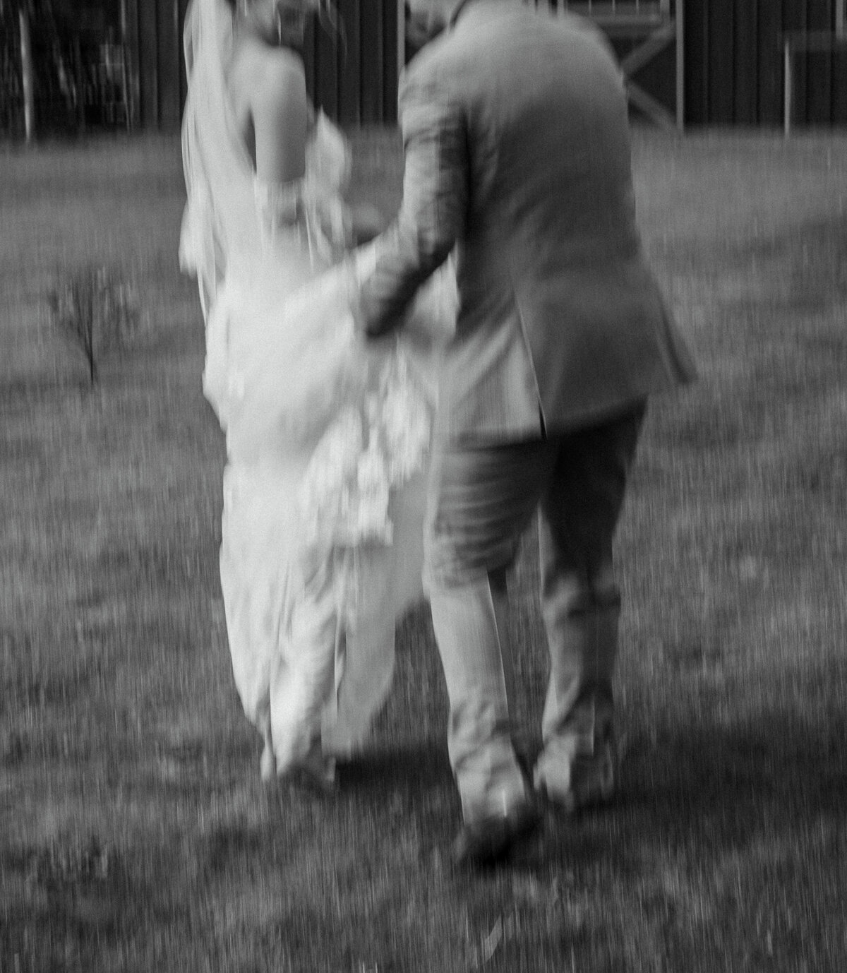 Groom holding bride's wedding dress train