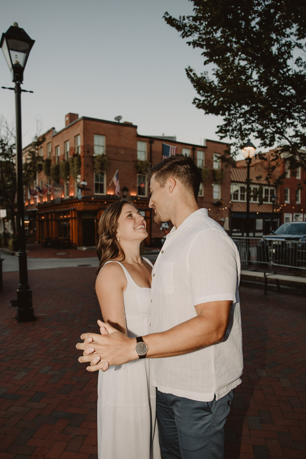 A couple dancing on the sidewalk in a city 