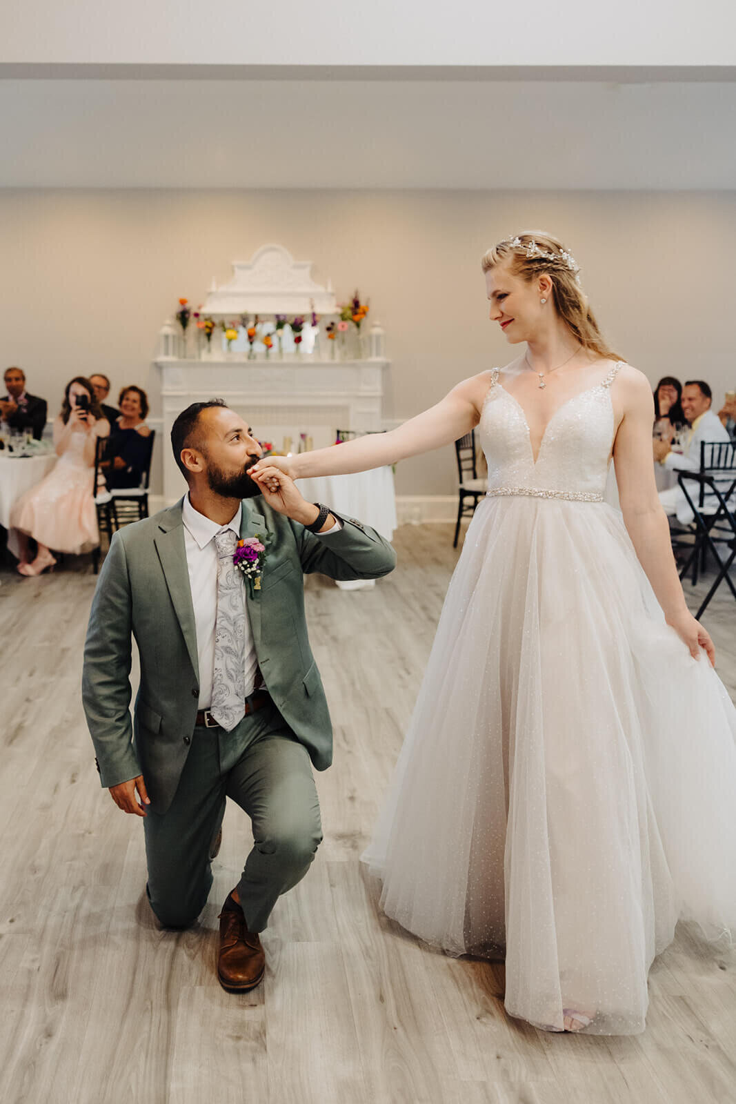 Groom on one knee kissing brides hand at The Mansion at Keuka Lake wedding, NY