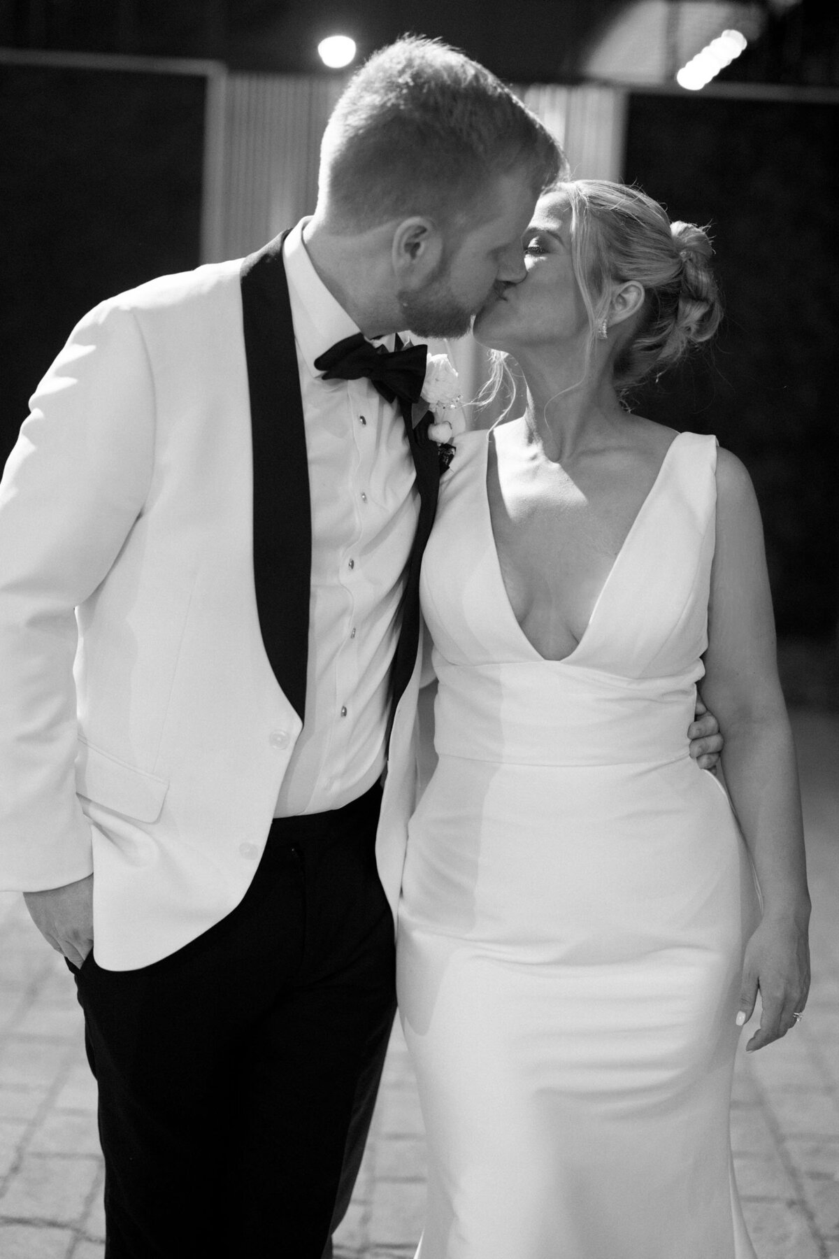 A cinematic black and white nighttime wedding portrait of a couple at Mae District, capturing an intimate and dramatic moment.