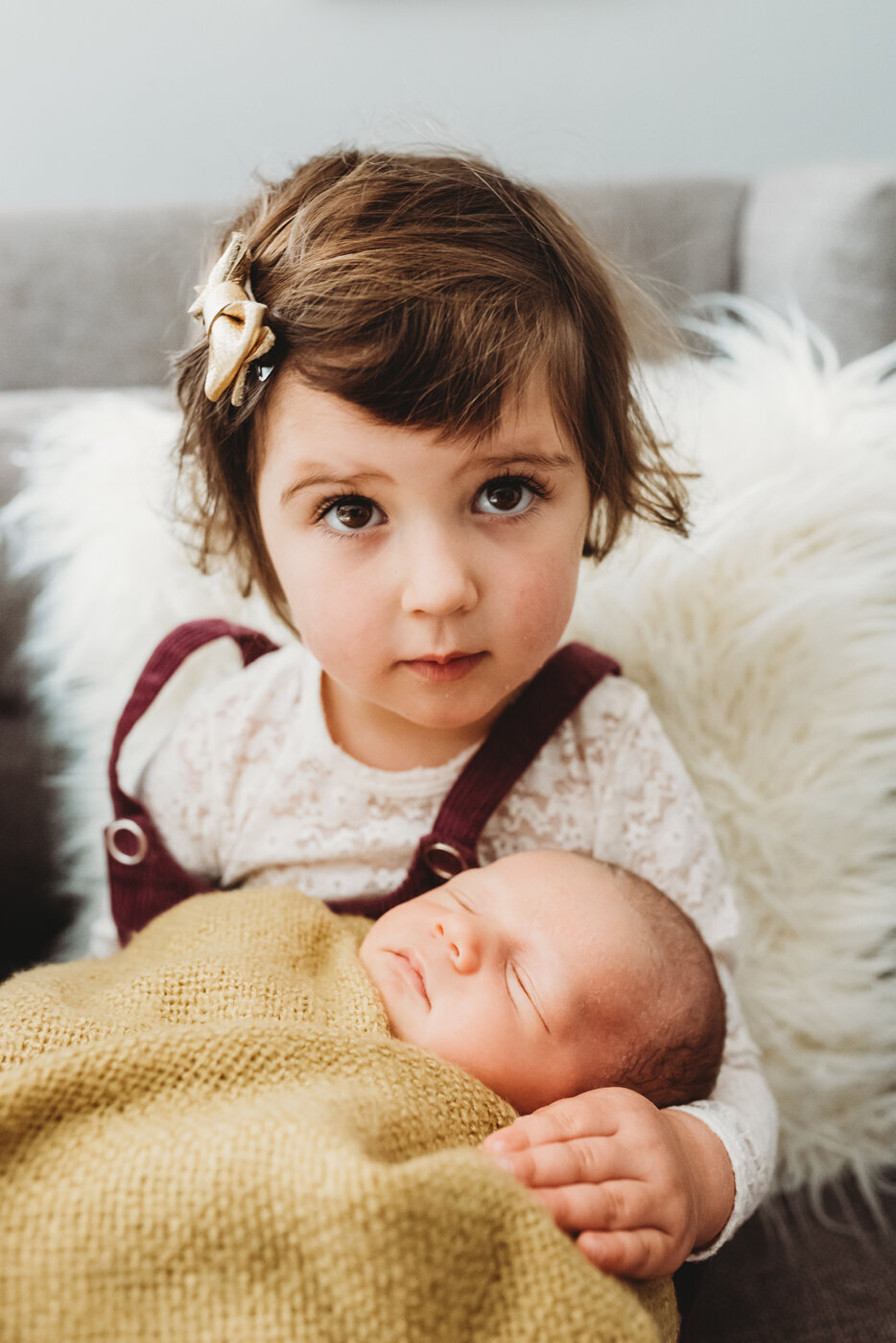 Baby girl holding her newborn baby brother