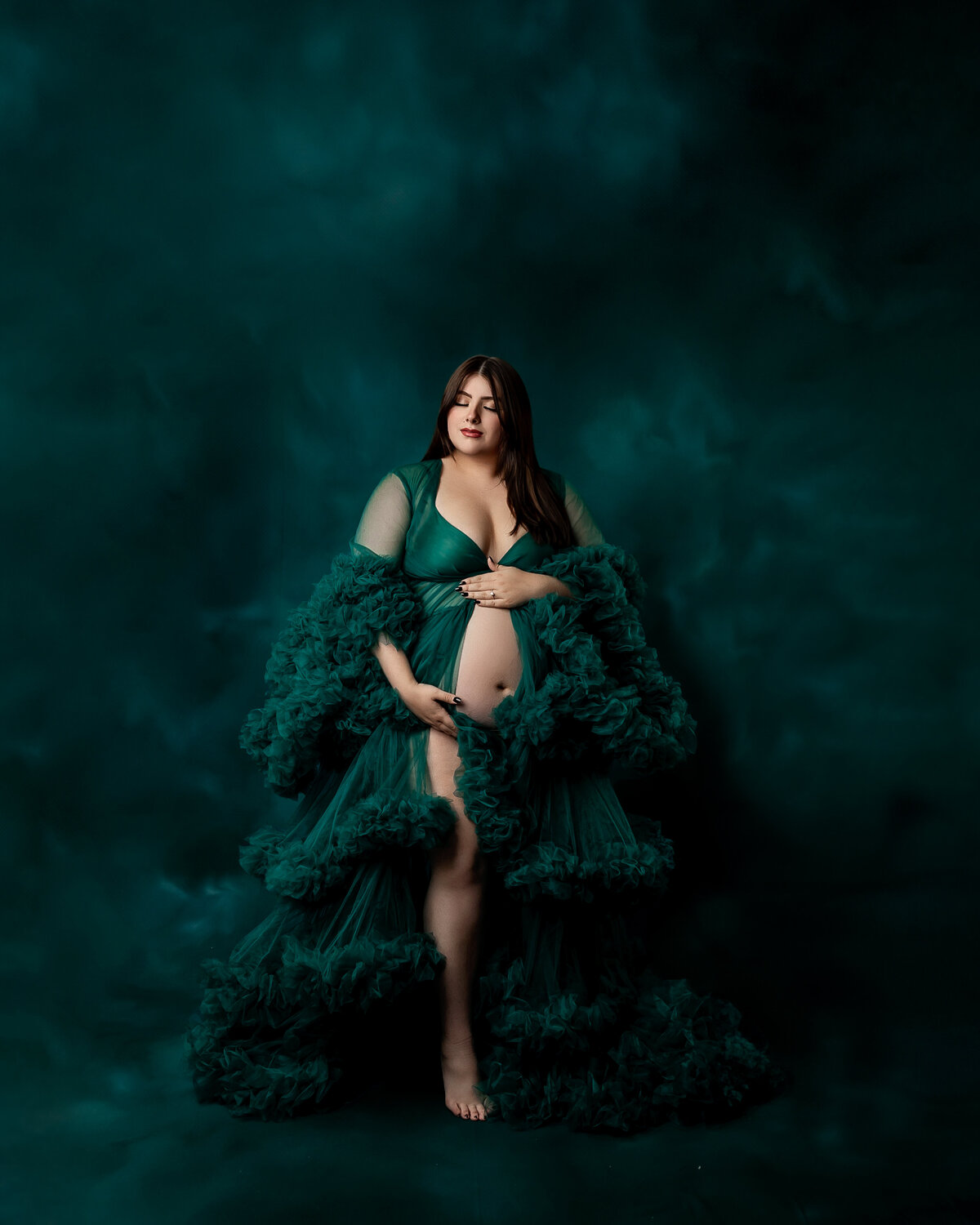 Stunning maternity portrait of a glowing mom-to-be in a luxurious emerald green gown, showcasing her baby bump. Captured by Inland Empire maternity photographer Kaitlyn Dawn Photography.