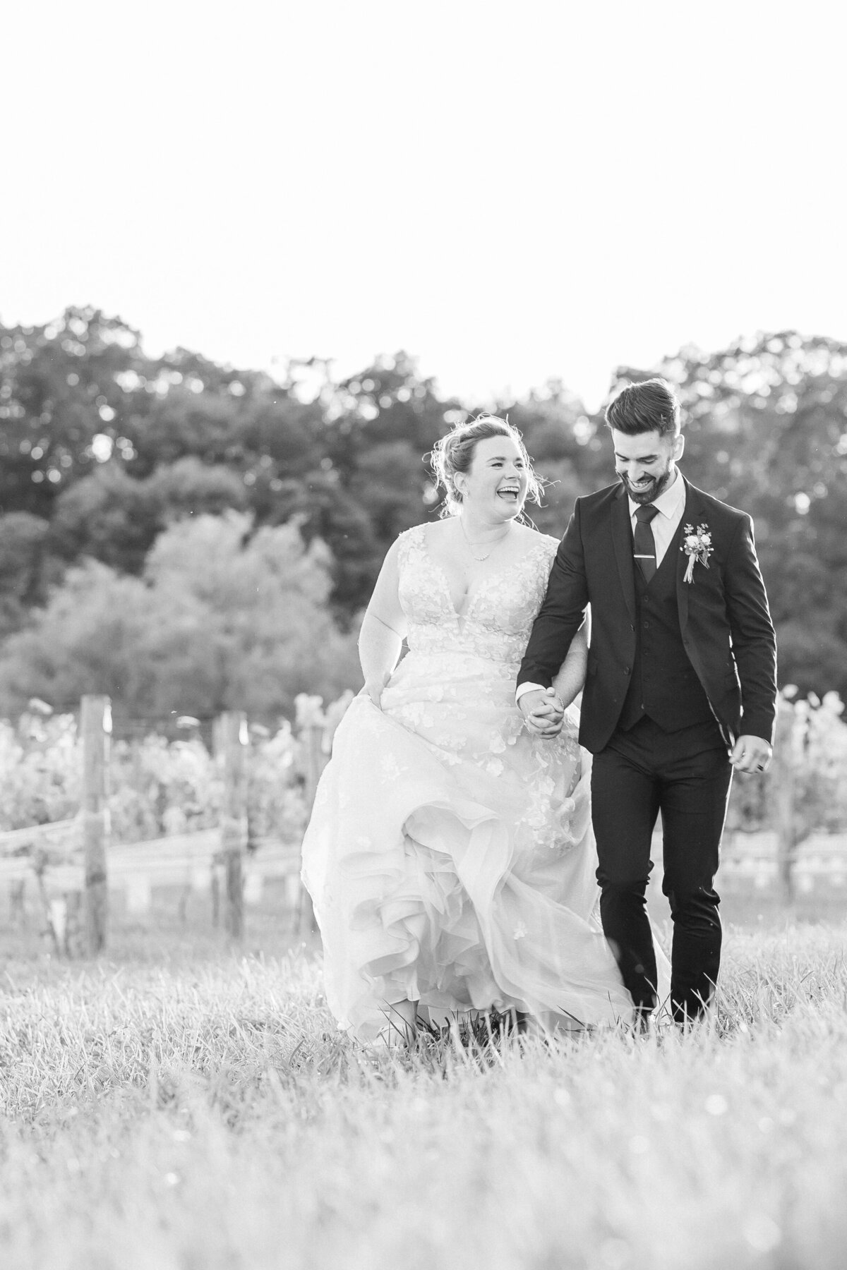 black and white photo of a couple laughing at sunset.