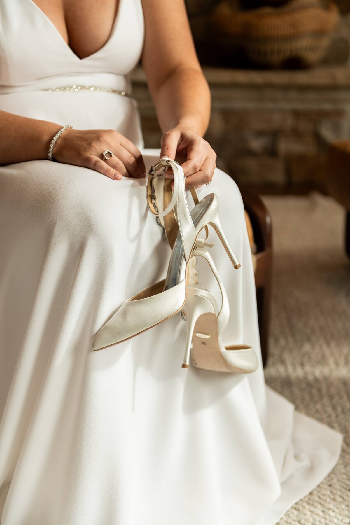 Bride prepares to put on her shoes for her wedding day.