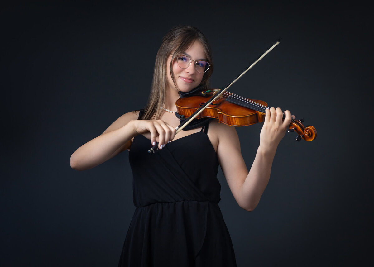 studio portrait of high school senior girl holding her violin