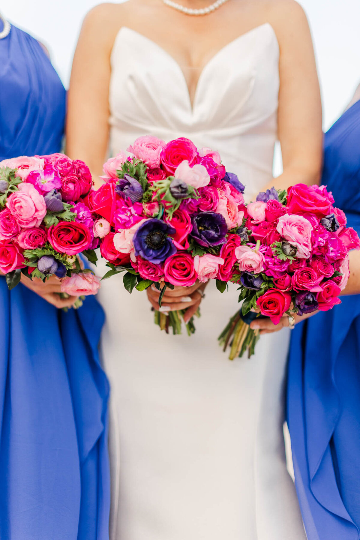 Detail photo of bride, and her bridesmaid holding bouquets towards the camera