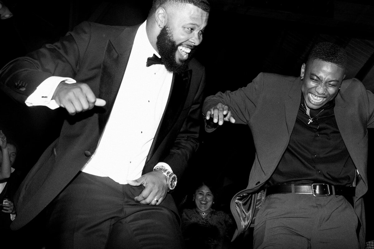Wedding Photography, black and white image of groom and friend dancing