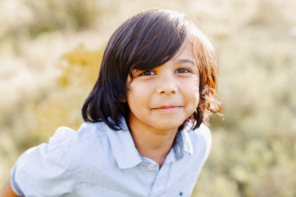 A silly boy leans in close for his portrait.