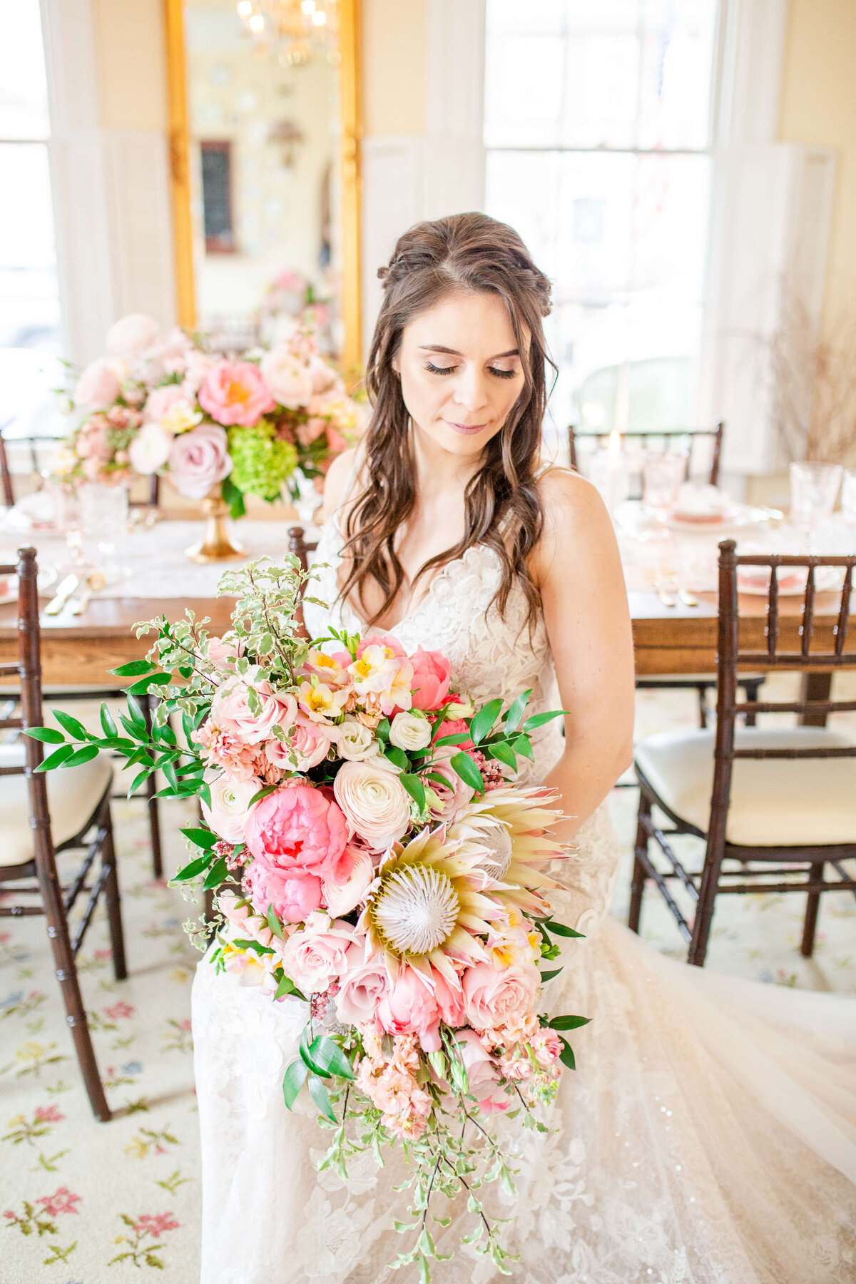 Bride-holding-bright-bouquet-wearing-wedding-dress-in-front-of-tablescape