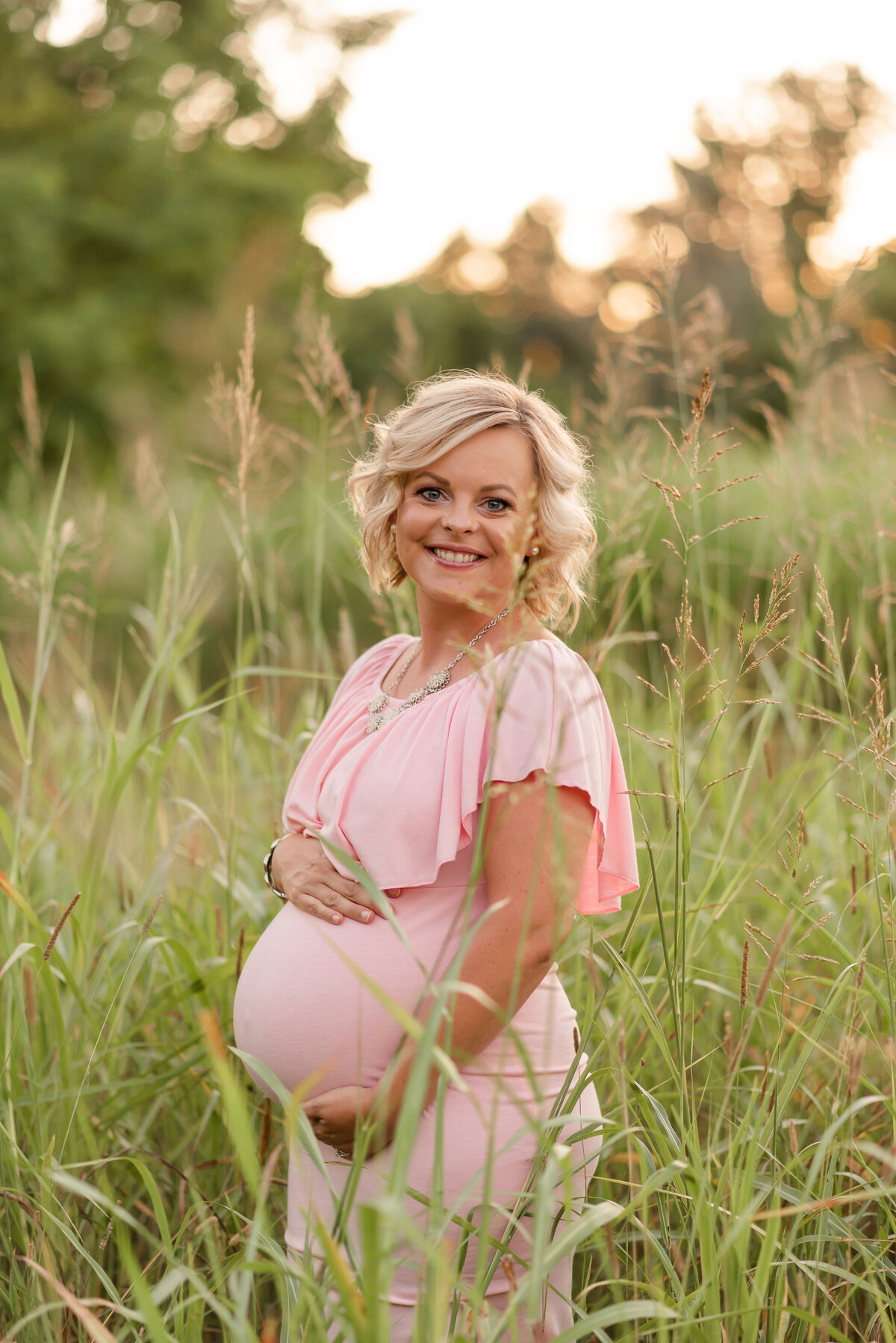 Maternity session with long pink dress at park  by Michelle Lynn Photography