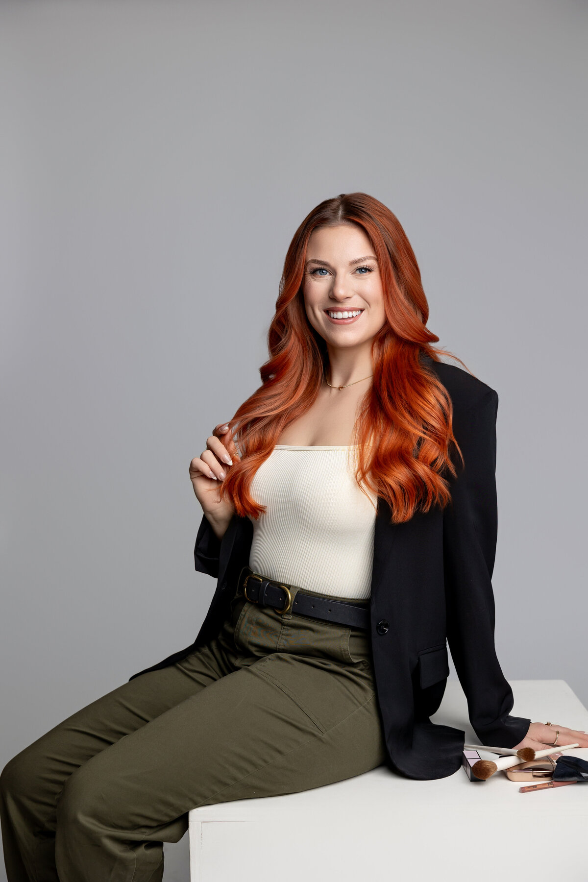 Studio branding portrait of red-haired woman seated with confident expression. Photograph by Yucaipa branding photographer Kaitlyn Dawn Photography.