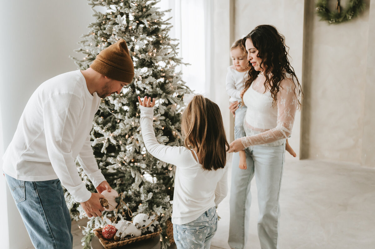 family setting up Christmas tree at Lighthouse Studios in Albuquerque, NM