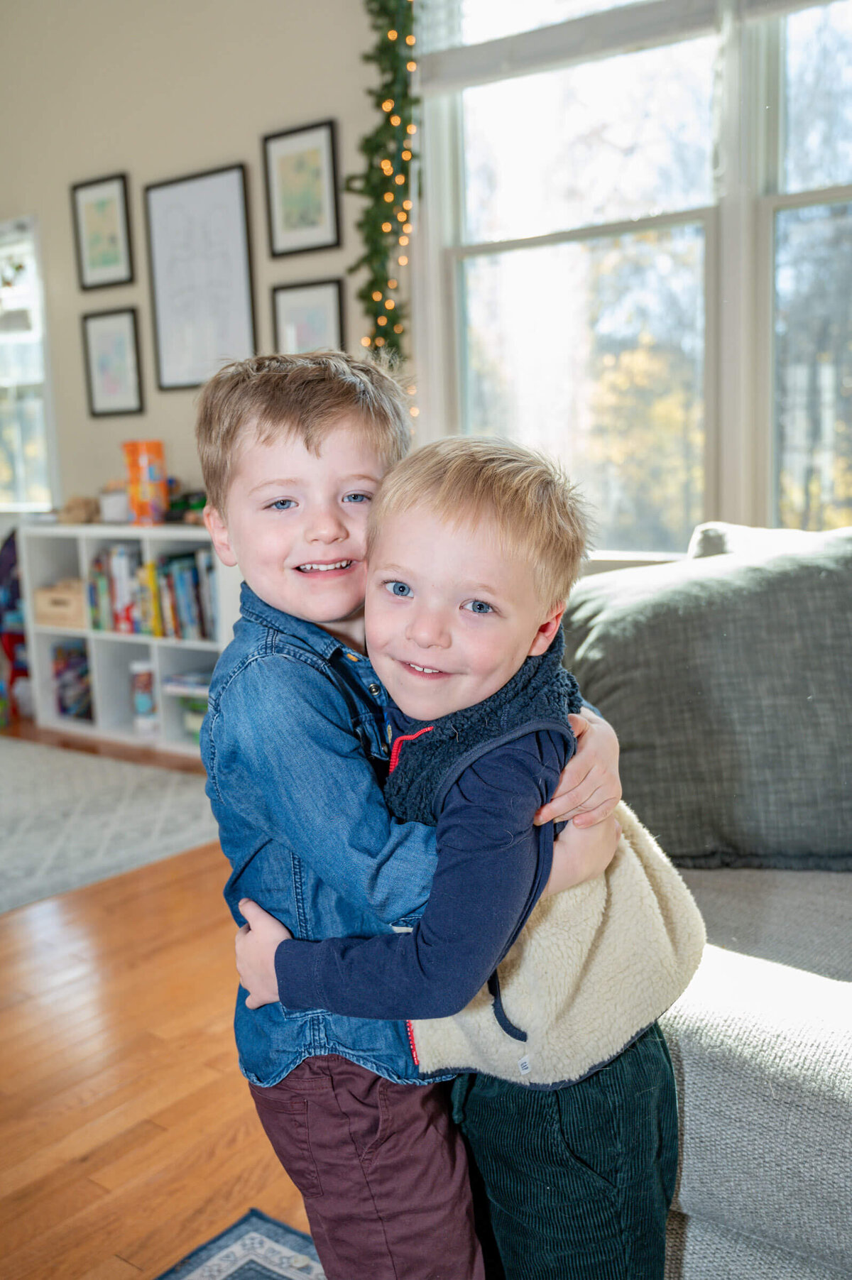 Two toddler brothers hugging each other, while smiling for a family session in Connecticut.