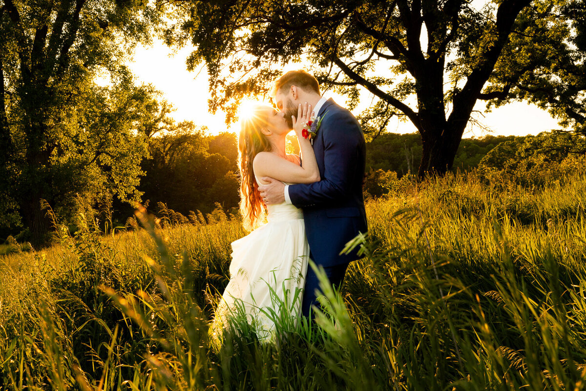 Bride and groom kiss in the sunlight at Almquist Farm in Hastings, Minnesota.