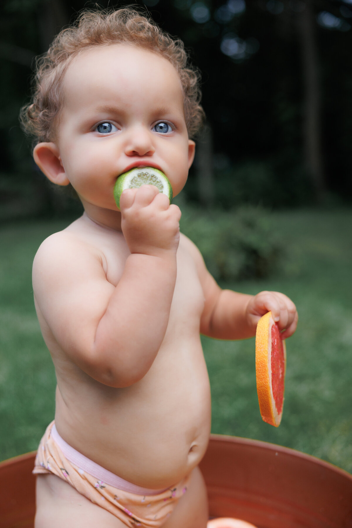 A cute baby in a fruit bath 