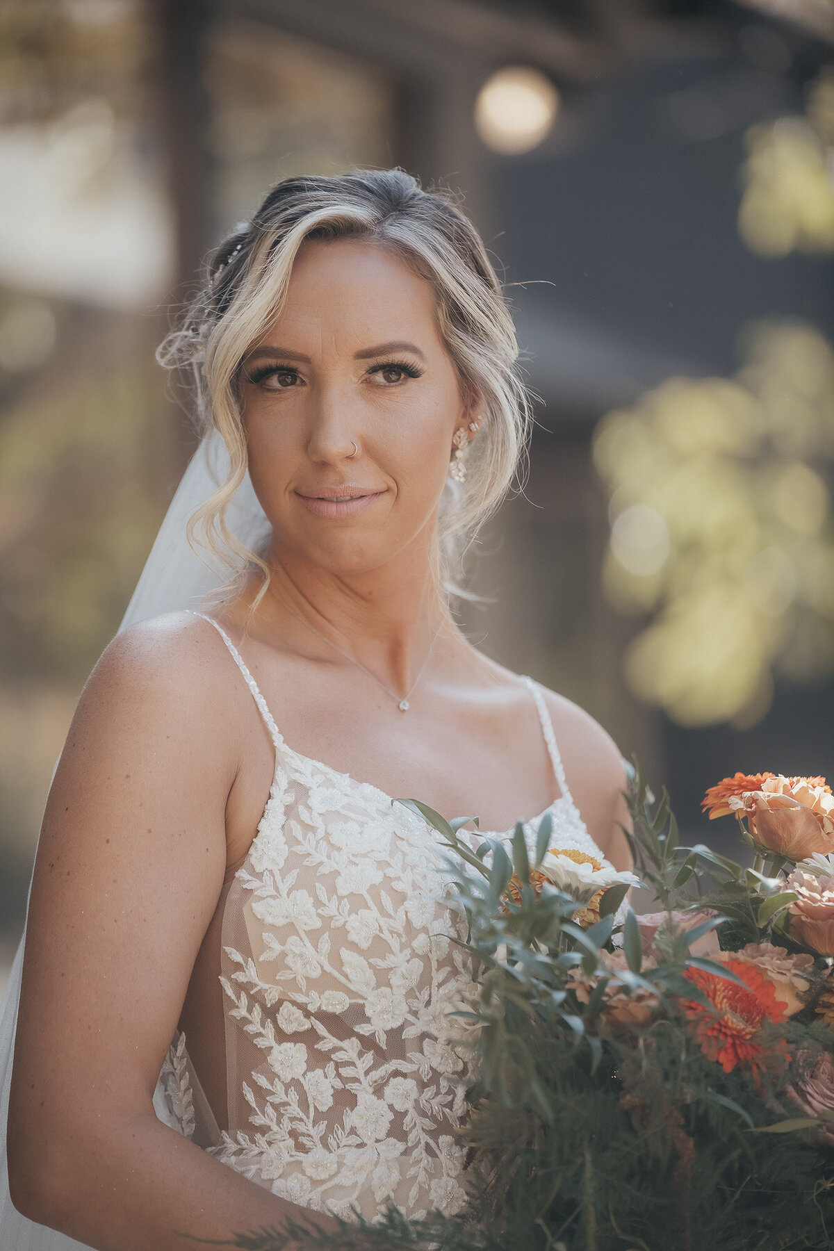 blonde bride holding orange and pink bouquet
