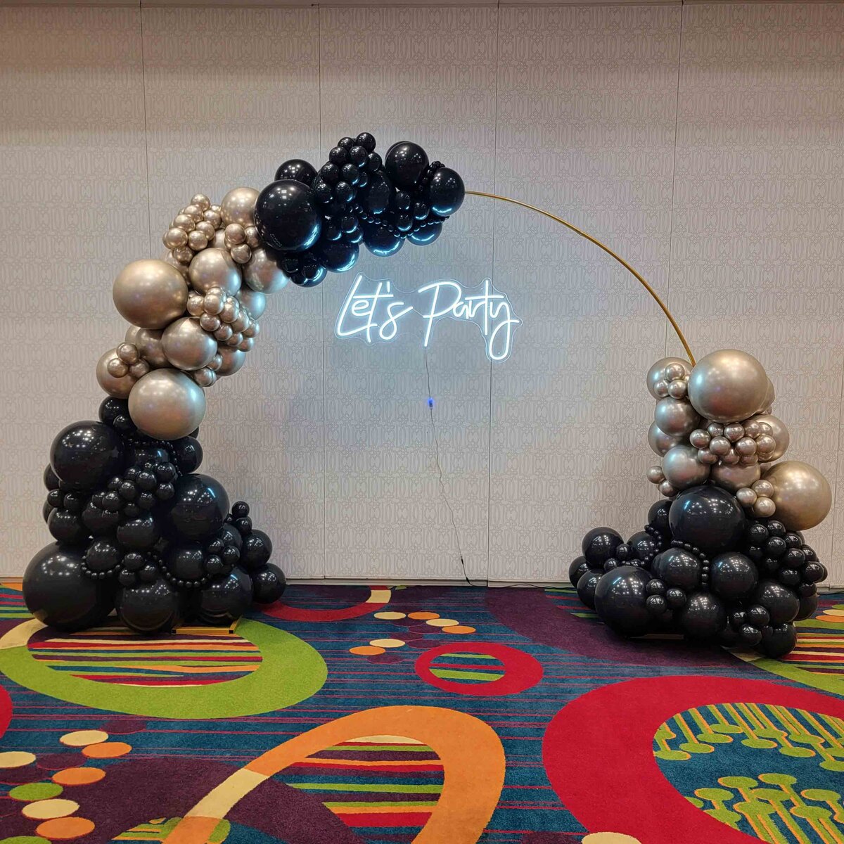 The celebration with Air with Flair Decor's Custom Balloon Installation, featuring the elegance of a Black and Gold Party Arch.