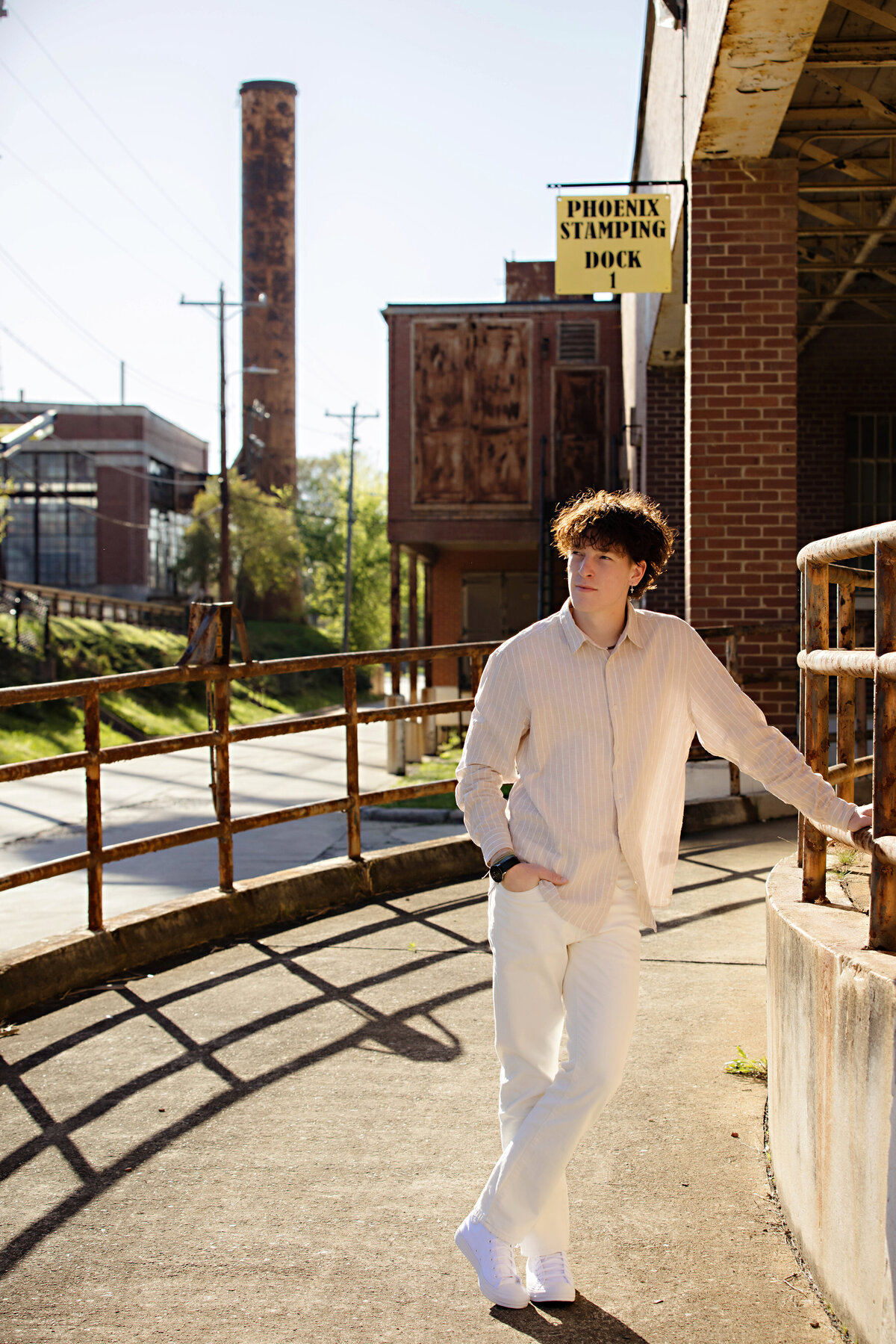 Editorial-style senior portrait on an industrial ramp in Charlotte NC, featuring a vintage spring outfit and confident pose.