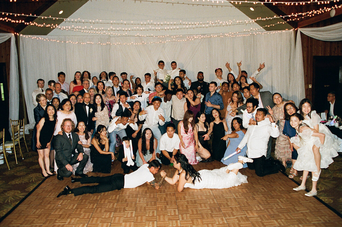 large group photo of everyone at the wedding reception on film