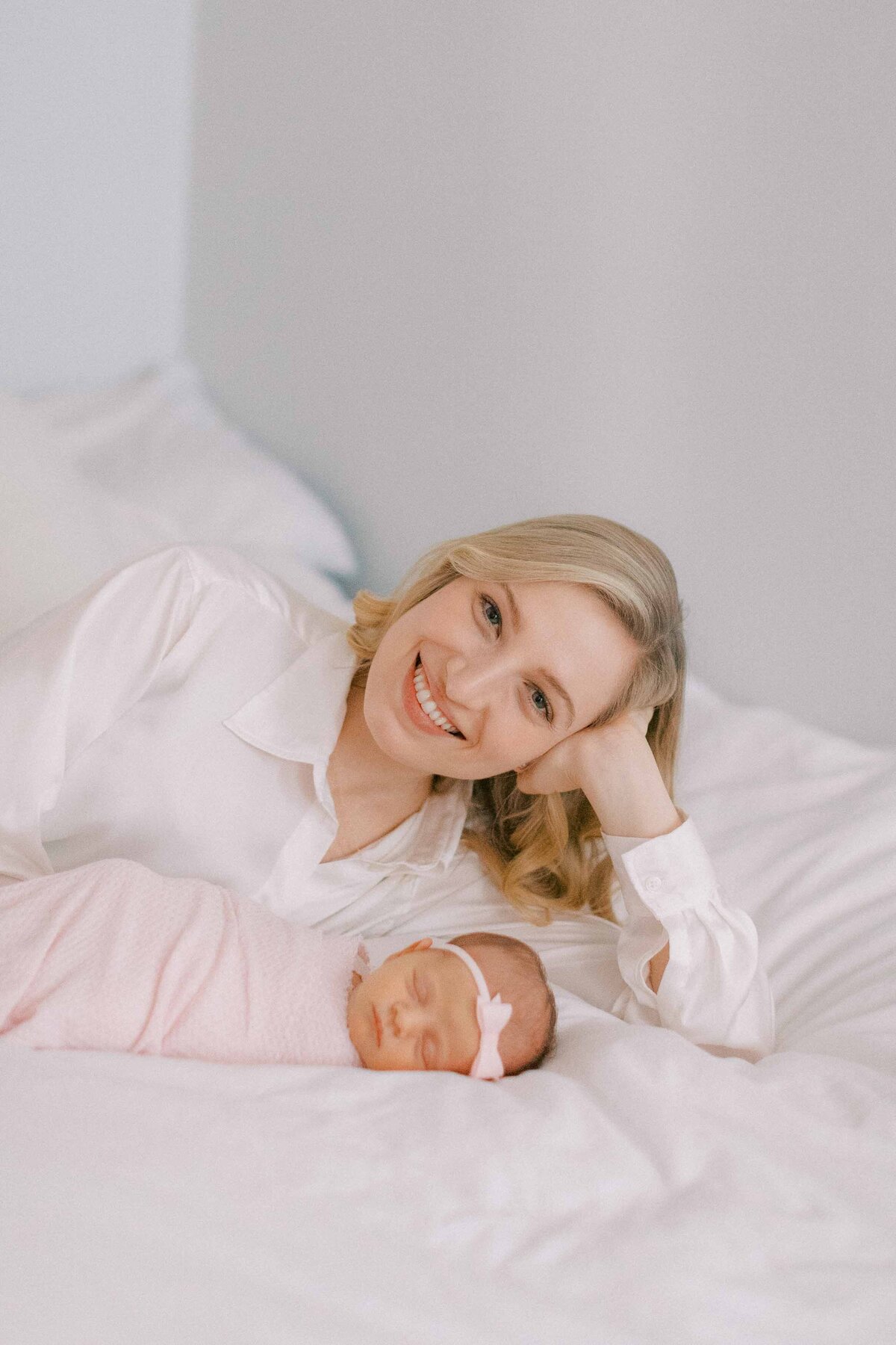 new mom laying next to her newborn baby girl