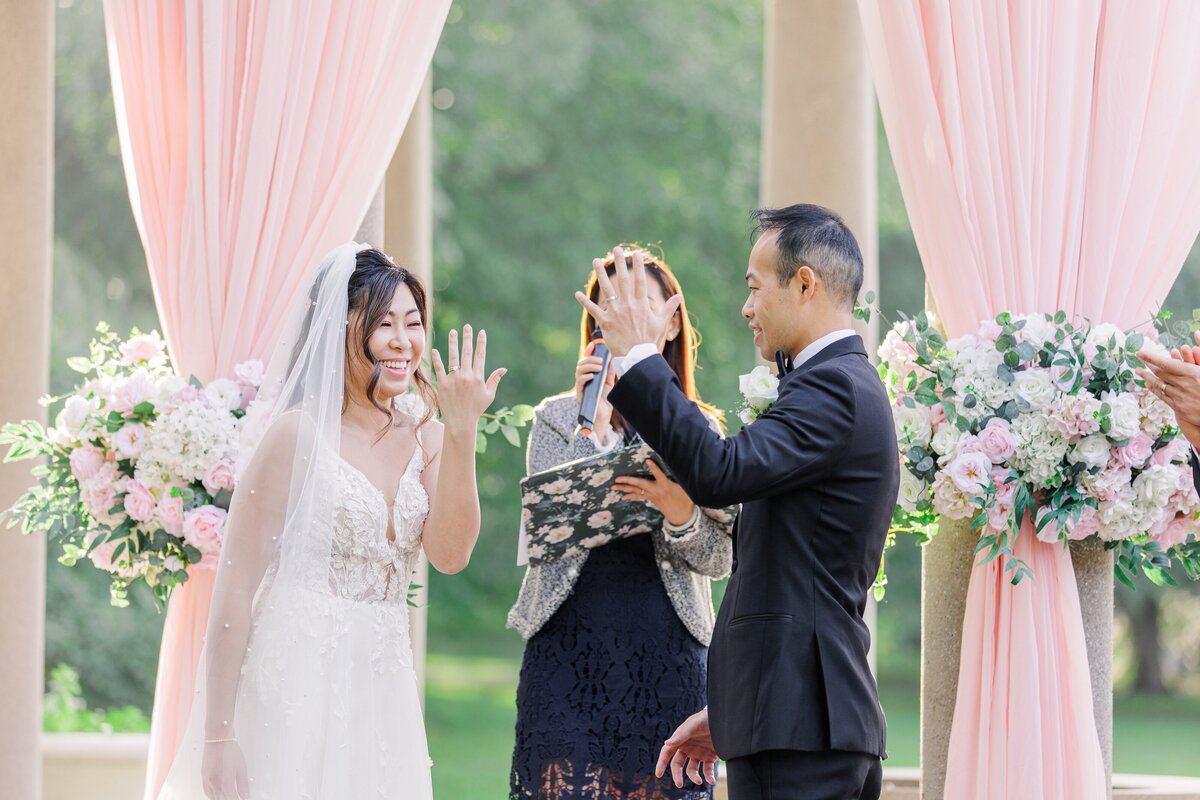 Bride and groom exchanging wedding rings during their Larz Anderson Park wedding