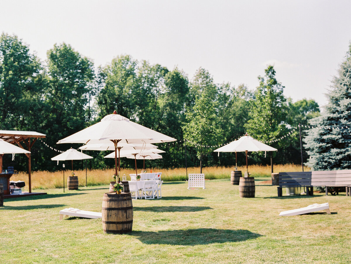 Exterior photo of barrel tables with white umbrellas in the Wildflower On Watts courtyard