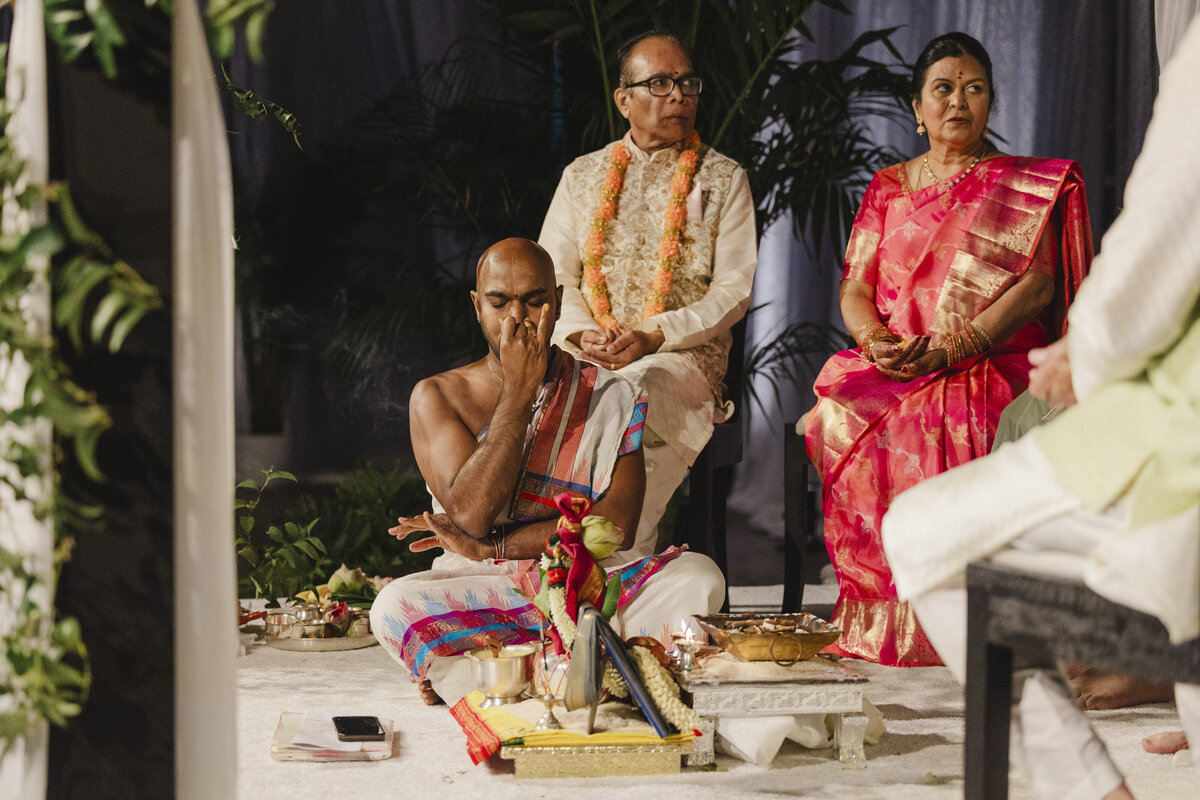 A person sitting on the ground during a traditional Indian wedding ceremony 