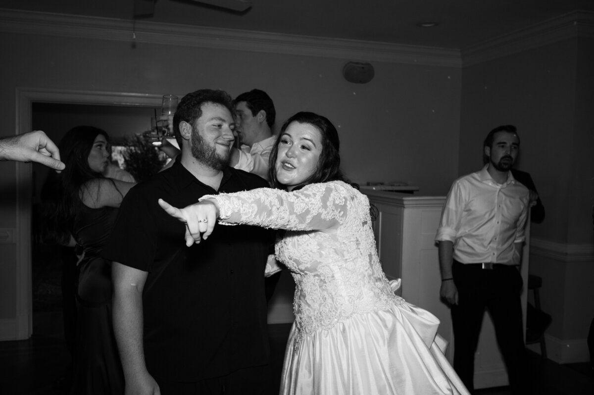 A newlywed dancing with a guest at her wedding reception