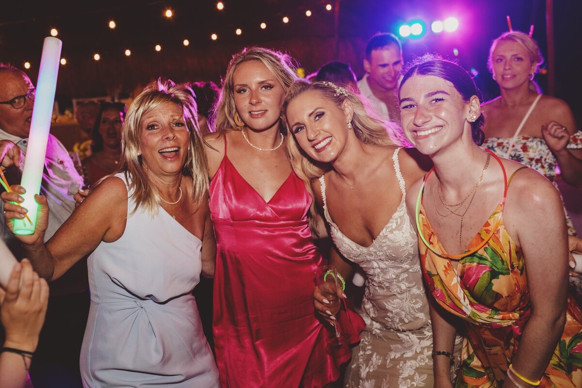 Guests and pose with bride at wedding reception in Cancun